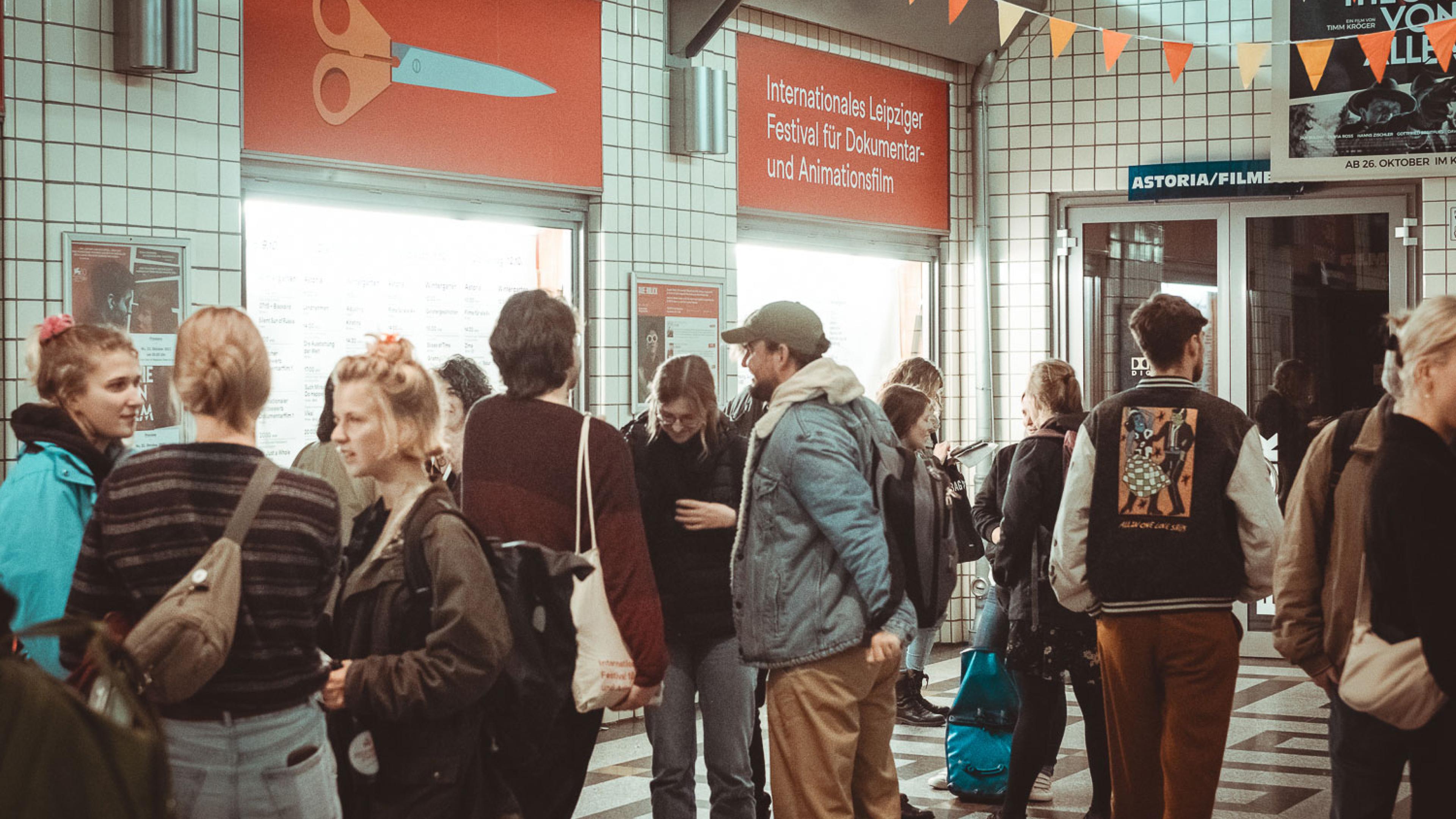 Eine Gruppe Kinobesucher*innen wartet vor den Passagekinos.