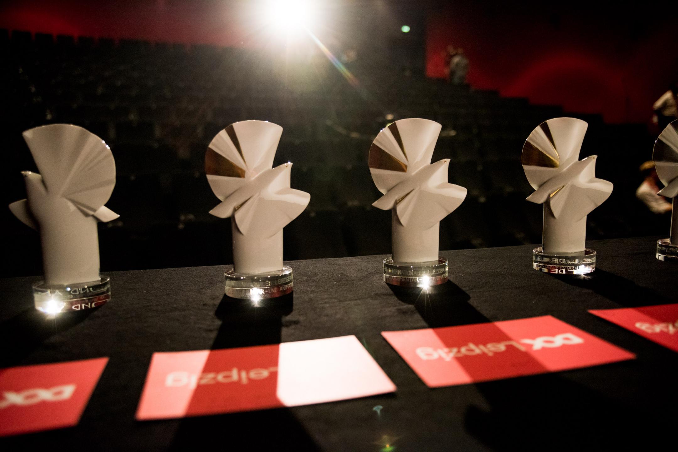 Several Golden Doves standing on a table, in the background you see the seating rows of a movie theatre.