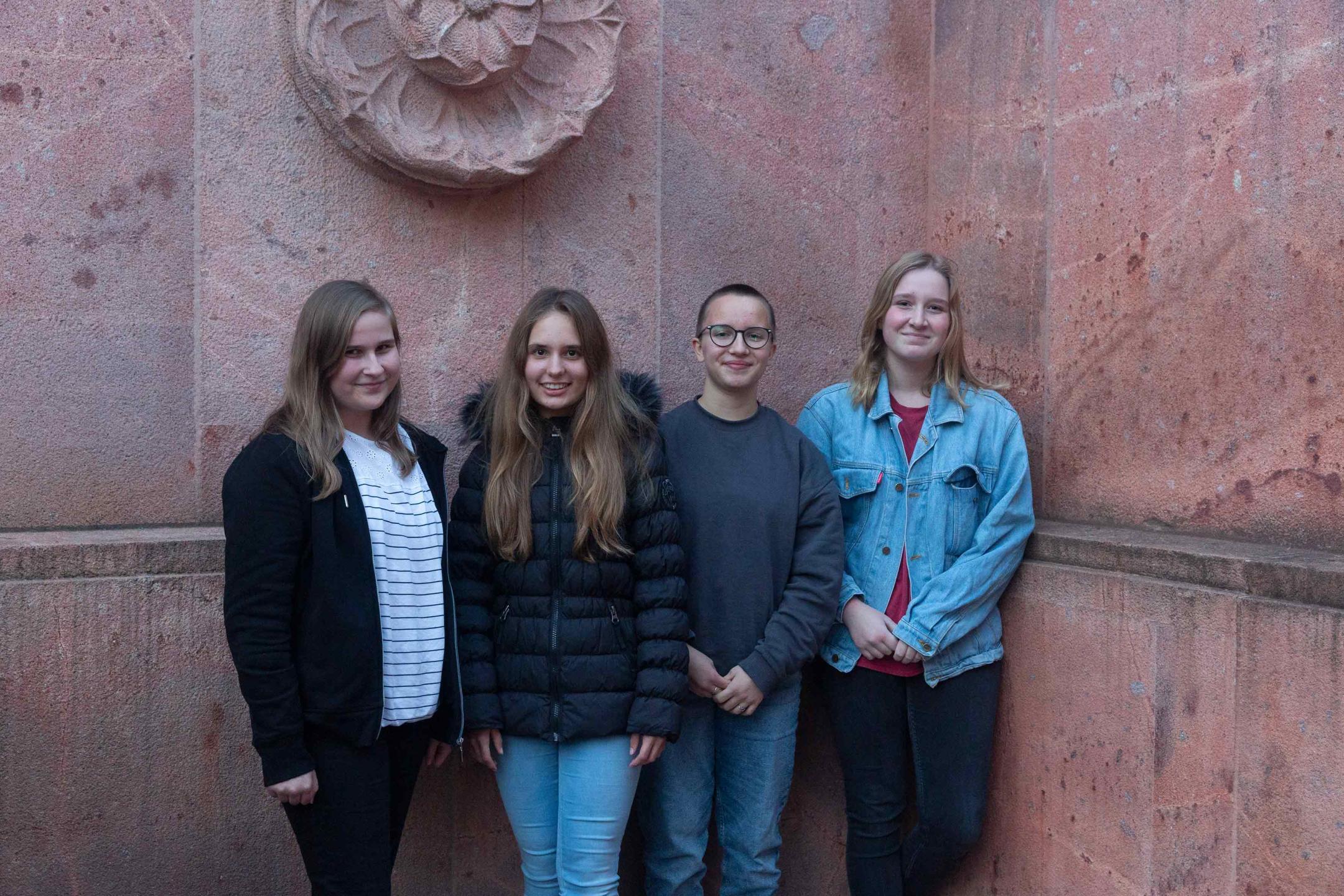 Vier Mitglieder der Jugendjury beim offiziellen Jury-Foto: Alle vier stehen nebeneinander und lächeln in die Kamera.