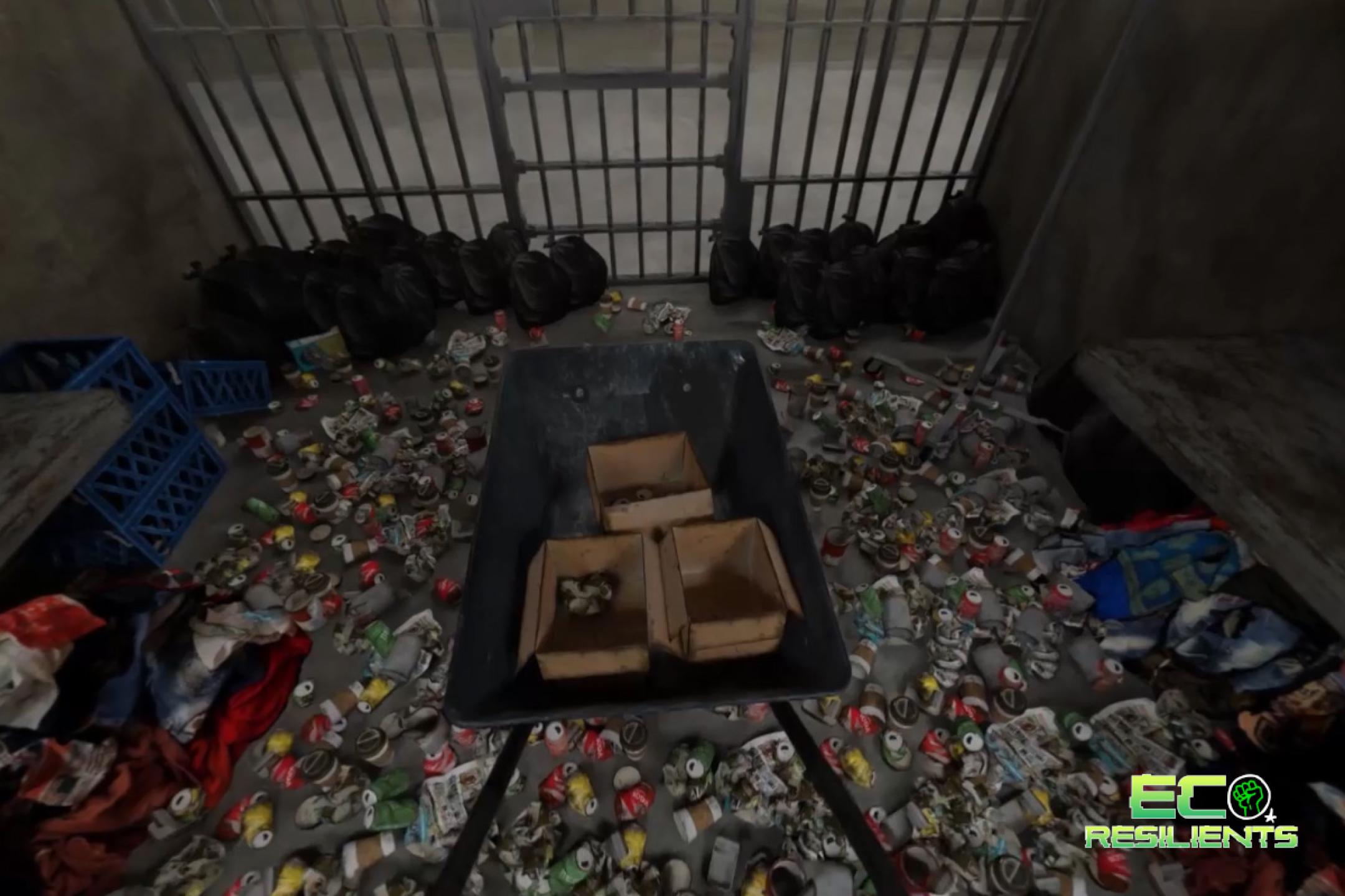 A prison cell where the floor is covered with cans and black garbage bags.