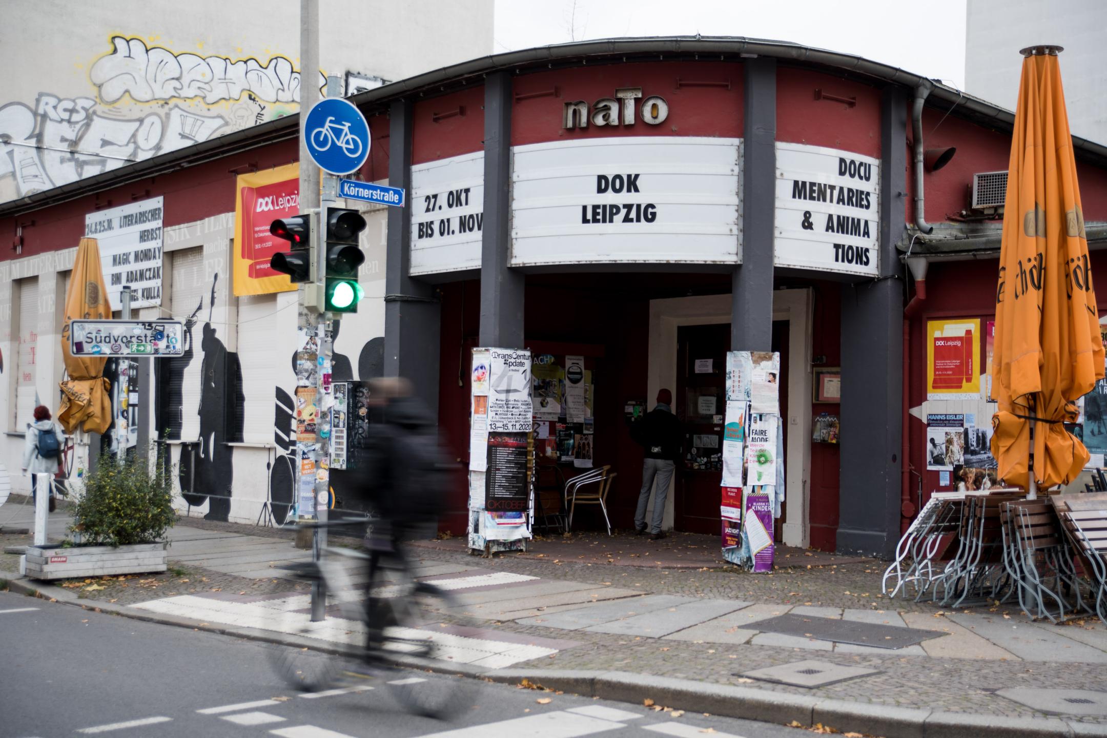 Ein einstöckiges Gebäude mit Schrifttafeln an einer Straßenkreuzung. Über dem Eingang steht: "naTo", darunter "DOK Leipzig".