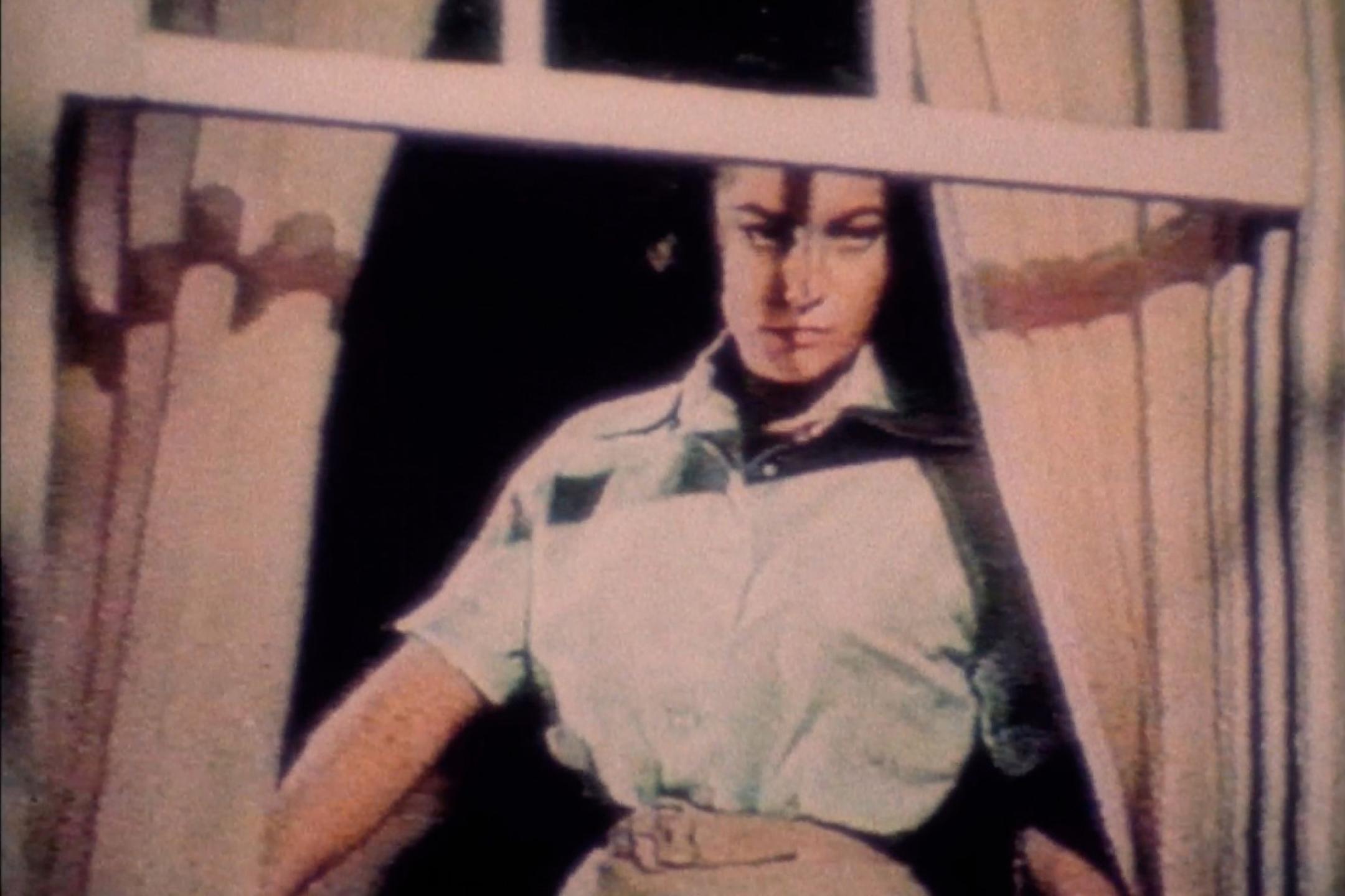 Eine Frau blickt aus einem Fenster.