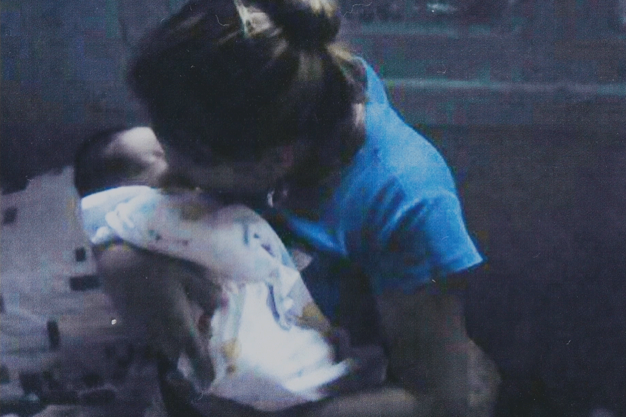 A woman hugs a baby in her harms.