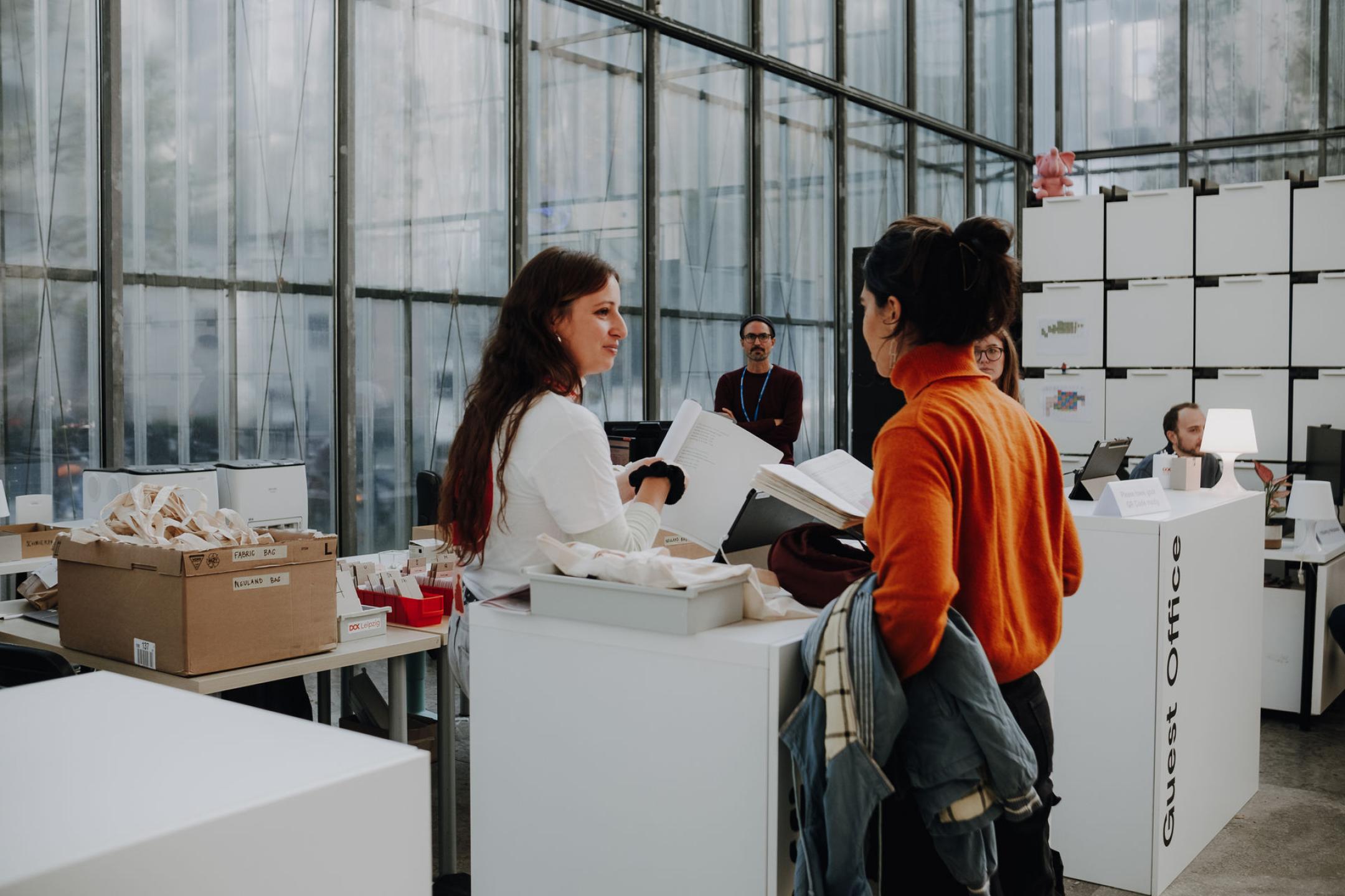 Eine Person hilft einer anderen Person am DOK Industry Stand