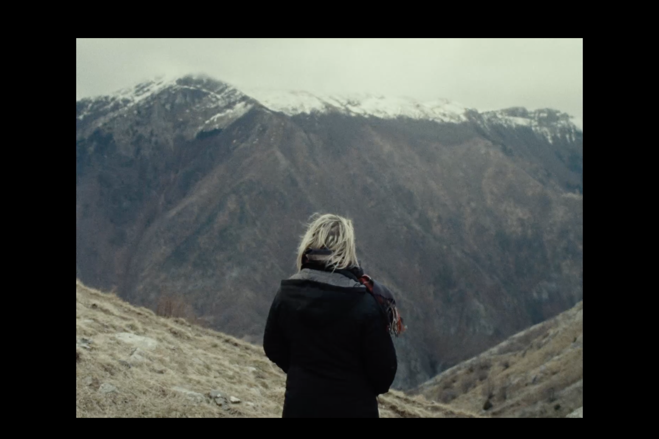 Person steht vor einem Bergpanorama