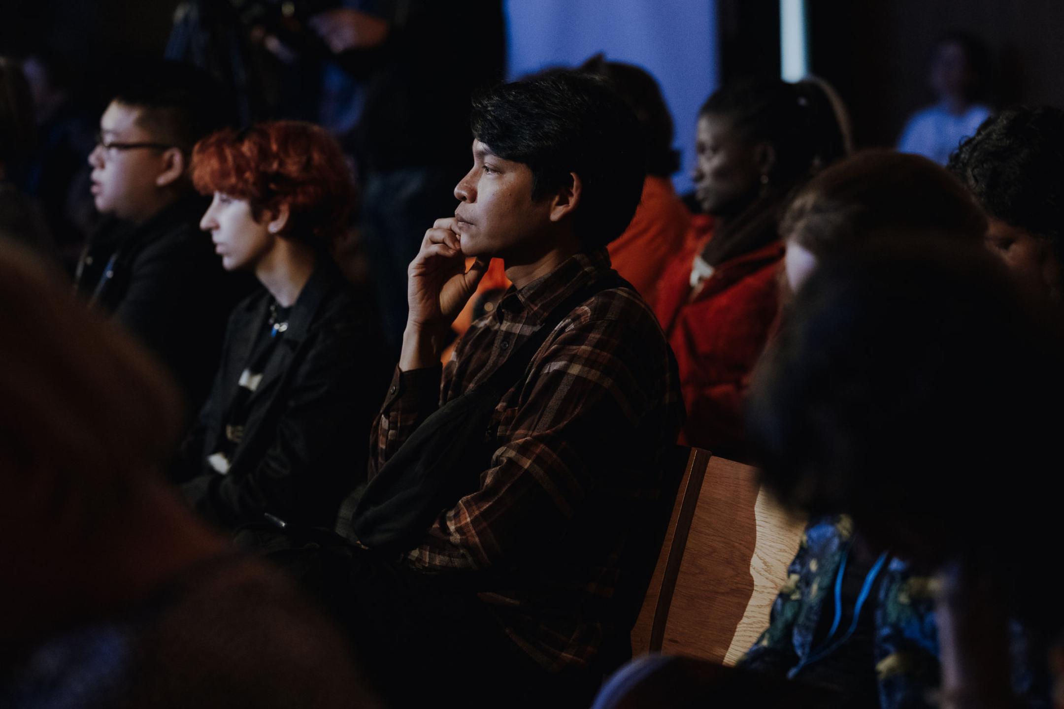 Person sitzt auf Stuhl und schaut nachdenklich nach vorne