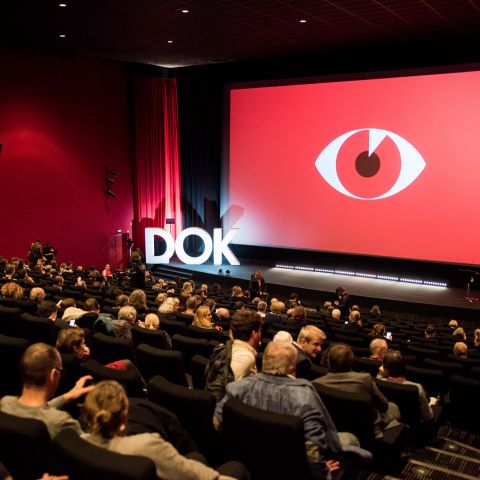 Voller Kinosaal mit dem roten Festivalmotiv zur DOK Leipzig Eröffnungsveranstaltung im CineStar.