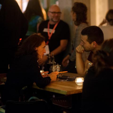 2 people sitting talking in a bar