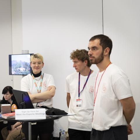 Drei Volunteers betreuen den Anmeldetisch eines Meet the Experts Meetings.
