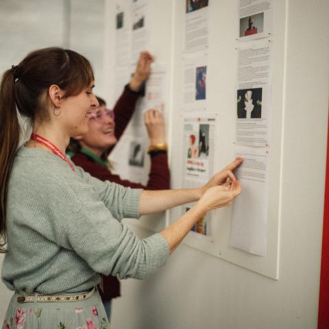 Neue Pressetexte werden an die Pressewand im Festivalzentrum gehängt.