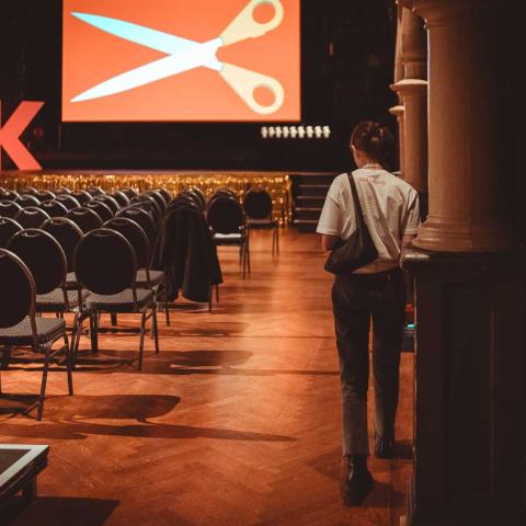 Ein Volunteer steht in einem leeren Saal, kurz bevor die Preisverleihung beginnt.