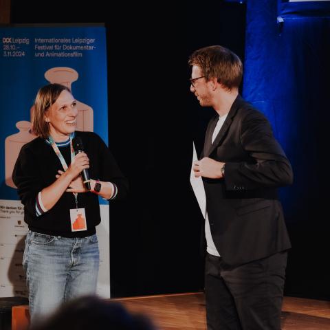 Alina Cyranek is beaming as she accepts the Dok Preview Germany prize on stage