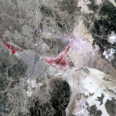 Ein Satellitenbild einer Landschaft mit einer Mine, daneben der Text: DOK Neuland: Immaterial