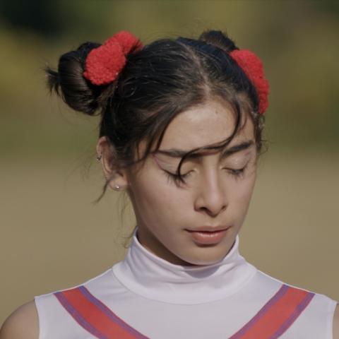 Girl in cheerleader outfit and shut eyes