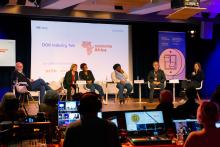 Fünf Panelist*innen und die Moderatorin des Talks "Generation Africa" unterhalten sich auf dem Podium. Davor ist ein Live-Schnittplatz mit mehreren Monitoren.