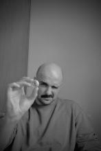 Portrait of Wiktor Filip Gacparski holding a shell close to the camera and squinting to see through it