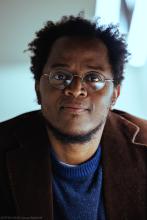 Schwarzer Mann mit kurzen Haaren und Brille