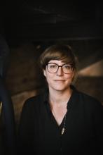 weiße Frau mit kurzen braunen Haaren und Brille