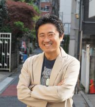 Lächelnder aiatischer Mann mit weißer Jacke