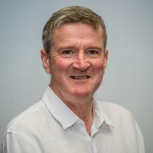 Portät eines weißen Mannes mit blonden Haaren und weißem Shirt