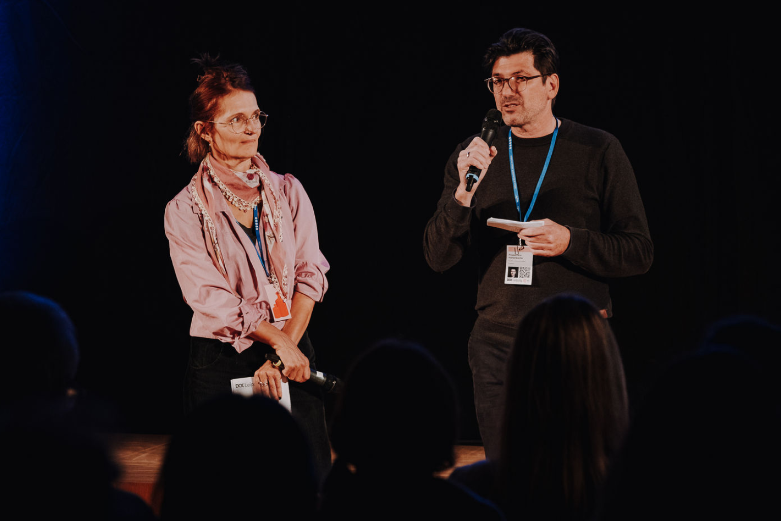 A man and a woman on stage pitching their documentary project.