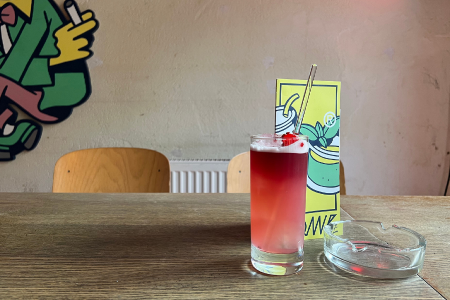 Red cocktail stands on a table in a bar