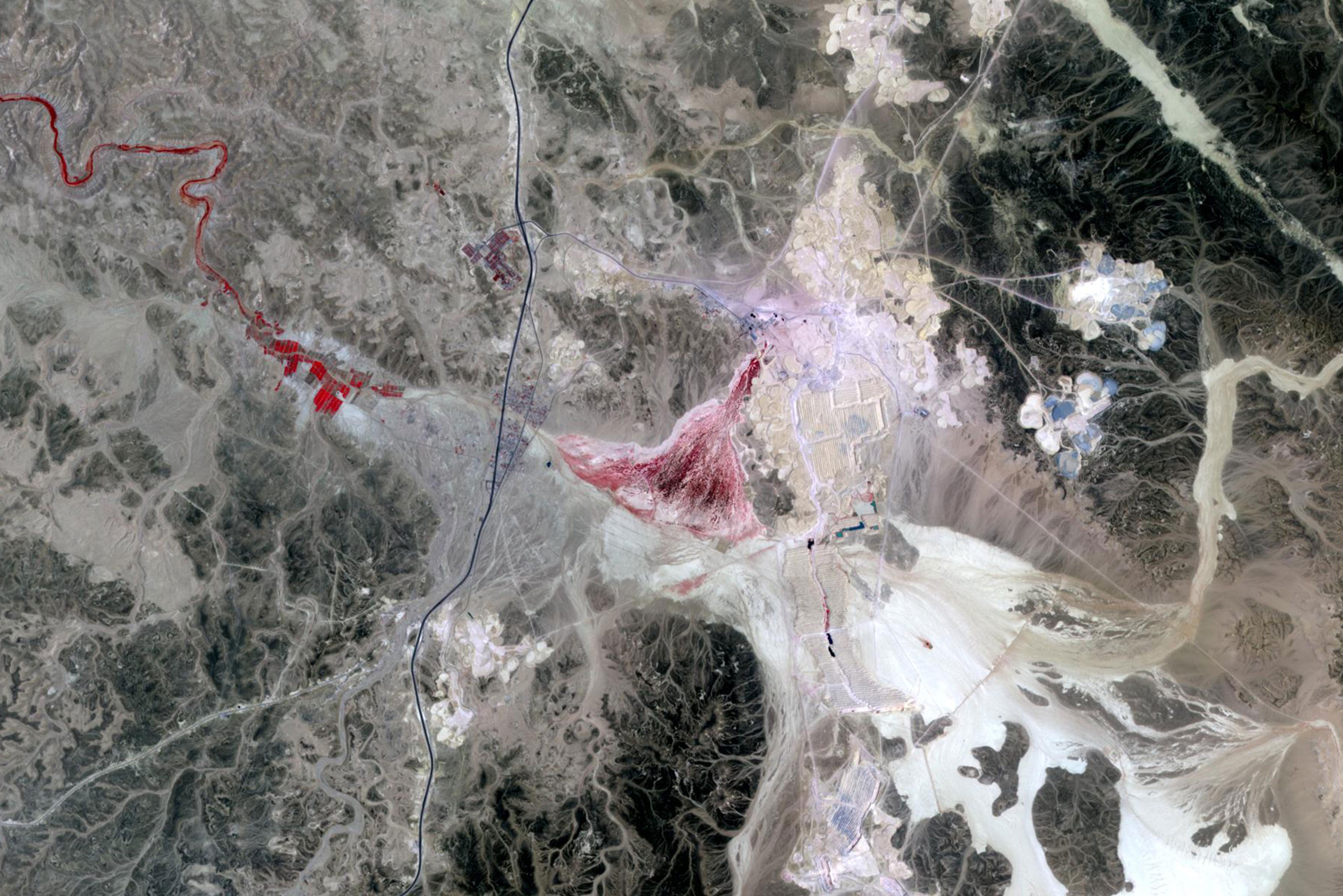 Ein Satellitenbild einer Landschaft mit einer Mine, daneben der Text: DOK Neuland: Immaterial