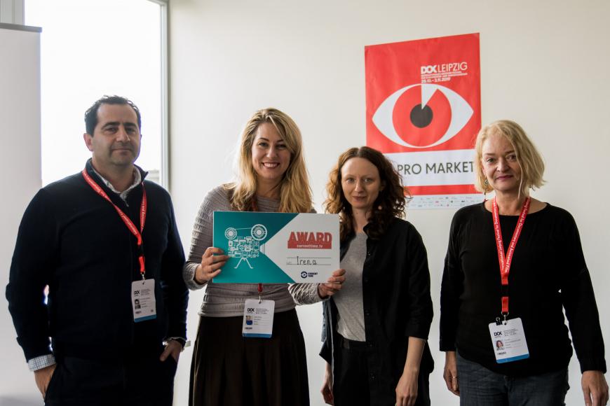 Four persons smiling into the camera, holding a certificate.