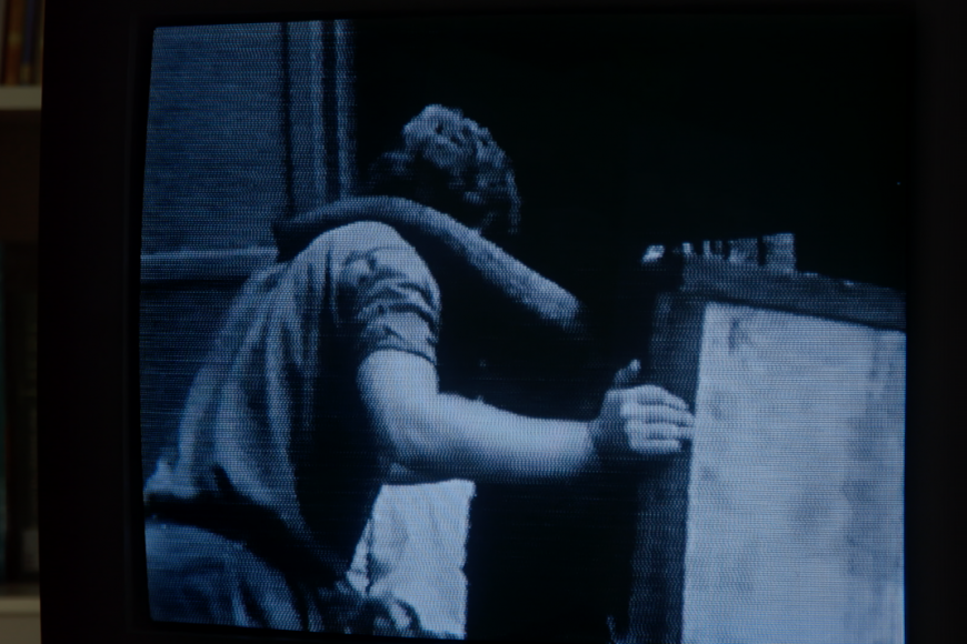 Bild von einem Monitor, auf dem ein Elefantenrüssel auf der Schulter eines Mannes ruht.