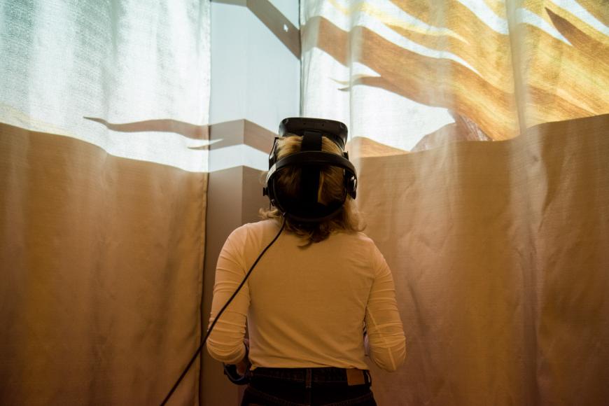 A female person with VR glasses is looking up.