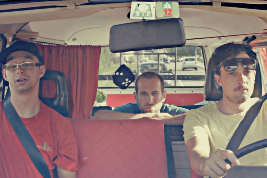 Drei Männer sitzen in einem VW-Bus.